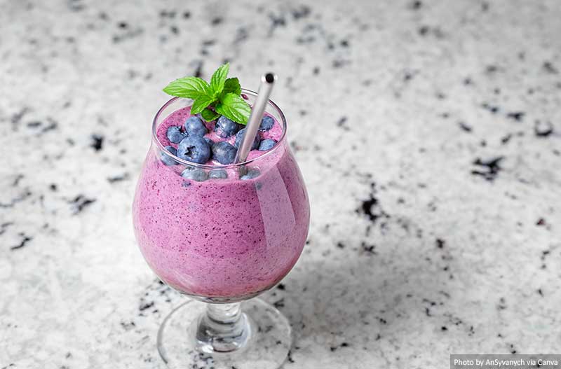 Blueberry smoothie in glass with reusable straw