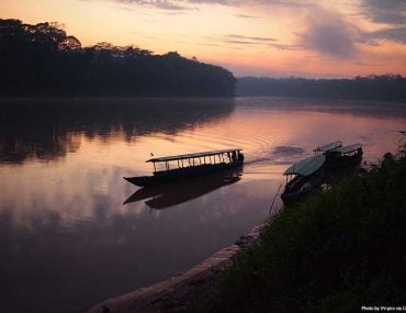 Amazon rainforest at sunrise with a boat