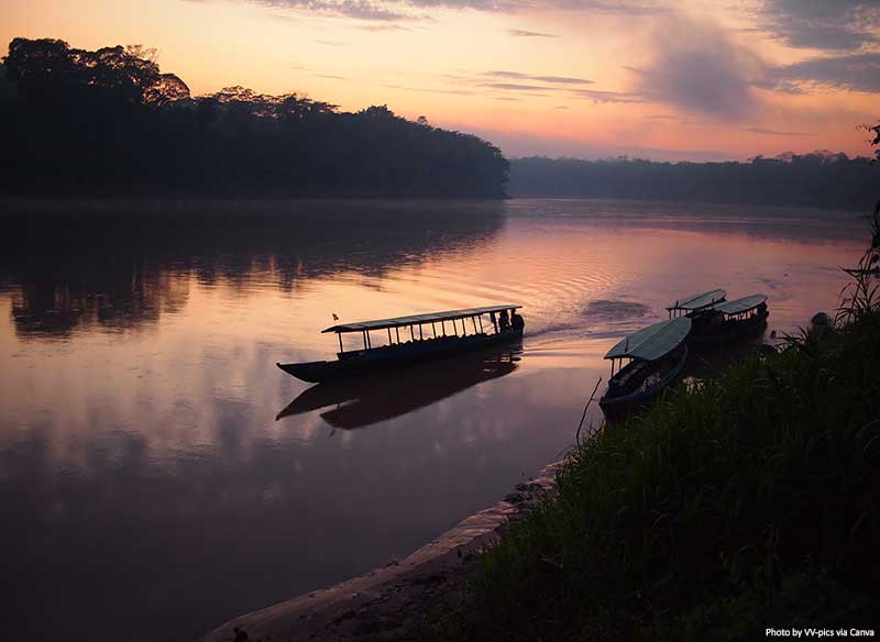 Amazon rainforest at sunrise with a boat