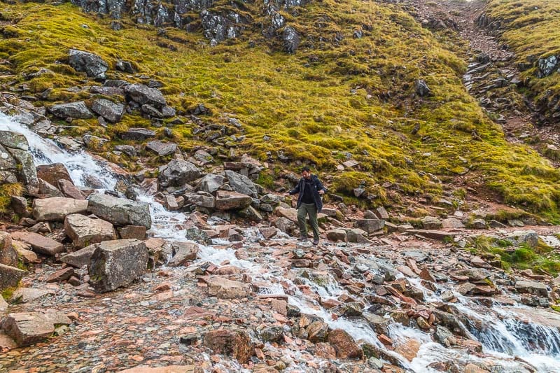 Walking over stream on the Ben Nevis Mountain Track