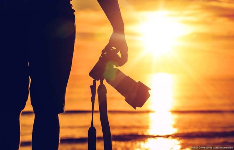 Photography holding a camera at sunset